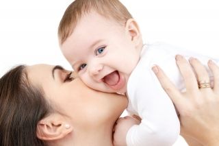 Baby being kissed by mom