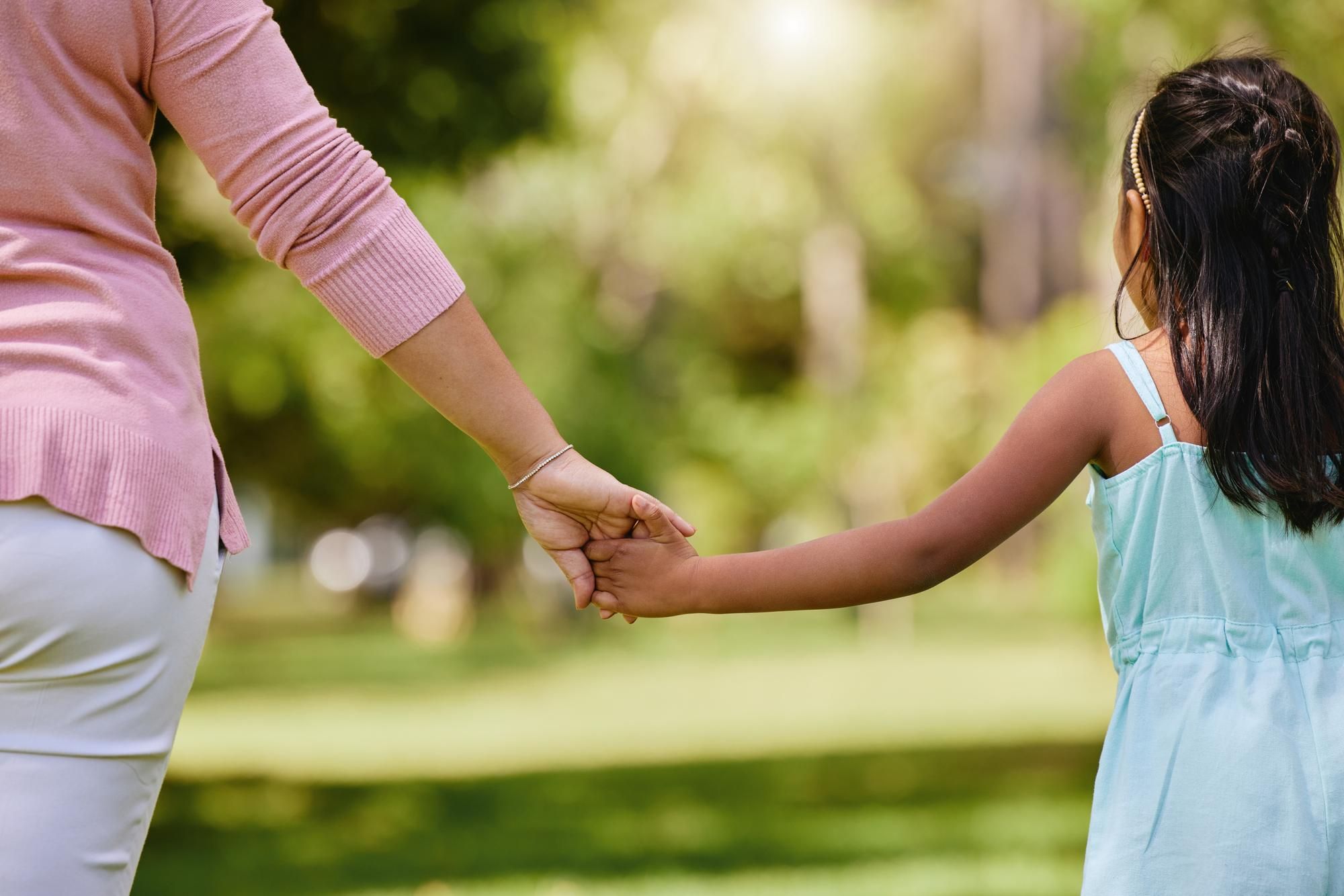 Child and adult holding hands